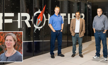 The award-winning research team standing in front of the Frontier supercomputer