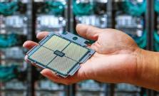 person's hand holding an APU processor with supercomputer racks in the background