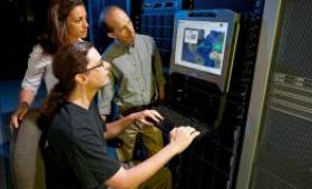 team looks on to previous generation supercomputer