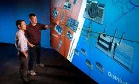 scientists pointing to screen with viewgraph of energy grid